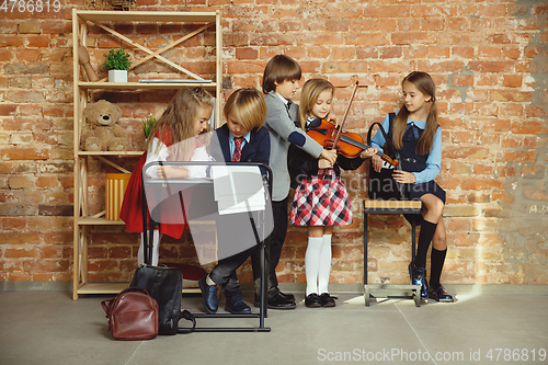 Image of Group of kids spending time after school together. Handsome friends resting after classes.