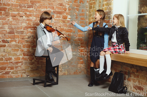 Image of Group of kids spending time after school together. Handsome frie