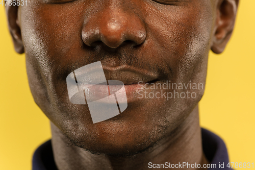 Image of African-american young man\'s close up portrait on yellow background