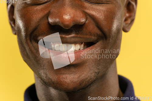 Image of African-american young man\'s close up portrait on yellow background