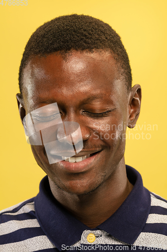 Image of African-american young man\'s close up portrait on yellow background