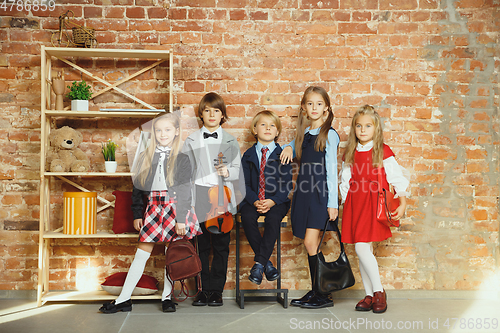 Image of Group of kids spending time after school together. Handsome friends resting after classes.