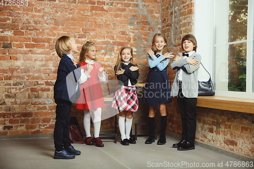 Image of Group of kids spending time after school together. Handsome friends resting after classes.