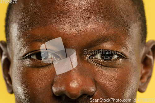 Image of African-american young man\'s close up portrait on yellow background