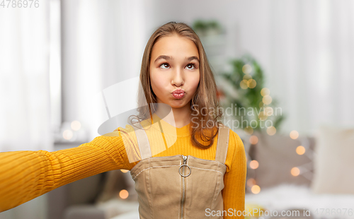 Image of funny teenage girl taking selfie at home
