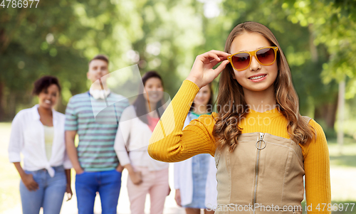Image of smiling teenage girl in sunglasses at summer park
