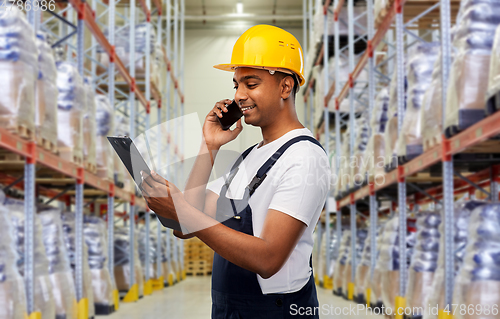 Image of indian worker calling on smartphone at warehouse