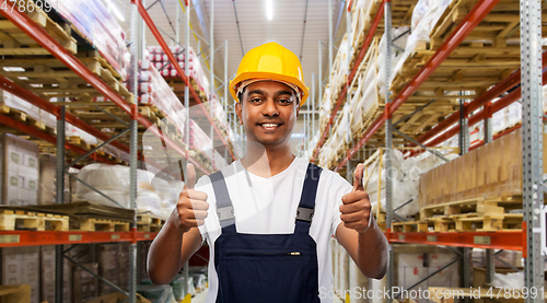 Image of happy indian worker showing thumbs up at warehouse