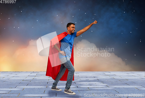 Image of indian man in superhero cape makes winning gesture