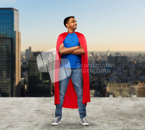 Image of happy indian man in red superhero cape in tokyo