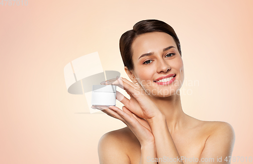 Image of happy young woman holding jar of cream