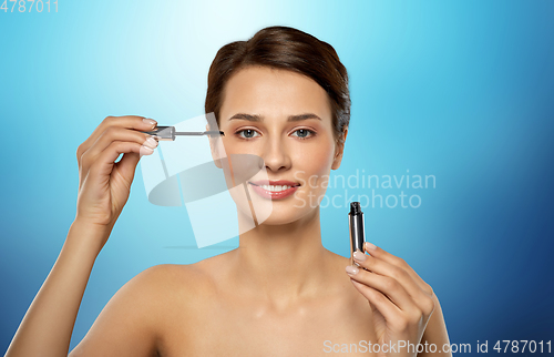 Image of beautiful woman applying mascara