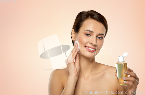 Image of young woman with toner or cleanser and cotton pad