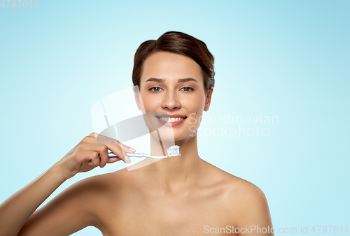 Image of smiling woman with toothbrush cleaning teeth