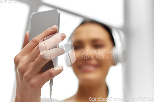 Image of close up of woman with smartphone and headphones