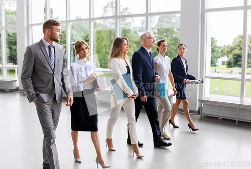 Image of business people walking along office building