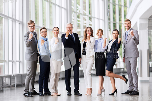 Image of happy business team celebrating success at office