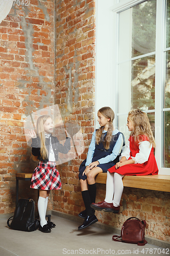 Image of Group of kids spending time after school together. Handsome friends resting after classes.