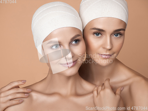 Image of Portrait of beautiful young women isolated on brown studio background