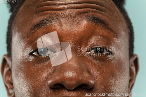Image of African-american young man\'s close up portrait on blue background