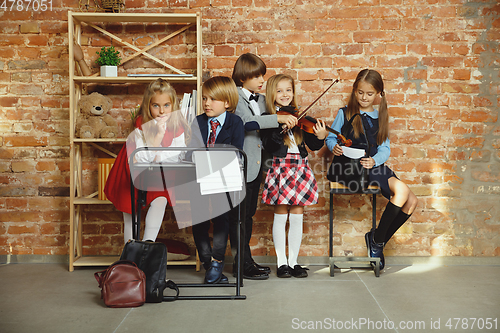 Image of Group of kids spending time after school together. Handsome friends resting after classes.