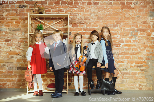 Image of Group of kids spending time after school together. Handsome friends resting after classes.