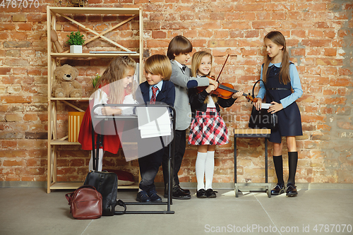 Image of Group of kids spending time after school together. Handsome friends resting after classes.