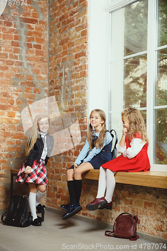 Image of Group of kids spending time after school together. Handsome friends resting after classes.