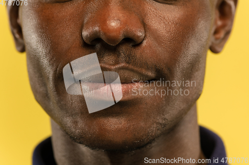 Image of African-american young man\'s close up portrait on yellow background
