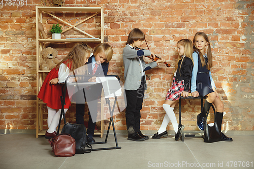 Image of Group of kids spending time after school together. Handsome friends resting after classes.