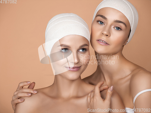 Image of Portrait of beautiful young women isolated on brown studio background