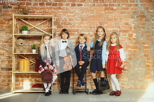 Image of Group of kids spending time after school together. Handsome friends resting after classes.