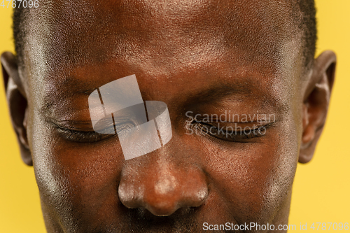 Image of African-american young man\'s close up portrait on yellow background