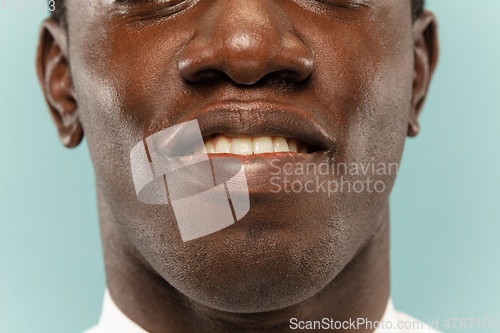 Image of African-american young man\'s close up portrait on blue background