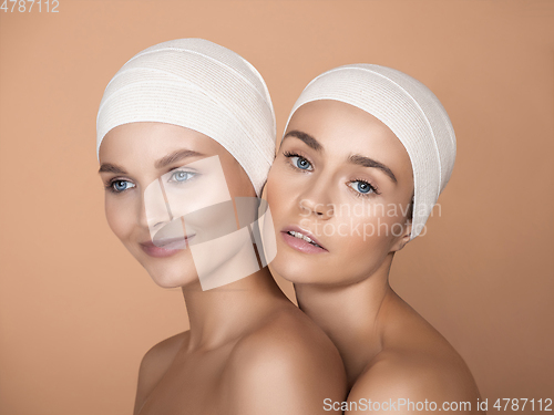 Image of Portrait of beautiful young women isolated on brown studio background