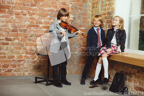 Image of Group of kids spending time after school together. Handsome frie