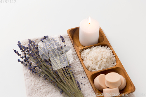 Image of sea salt, soap, candle and lavender on bath towel