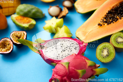 Image of different exotic fruits on blue background