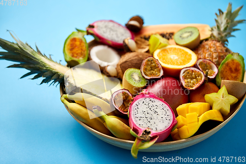 Image of plate of exotic fruits on blue background