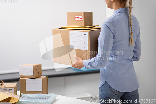 Image of woman walking with parcels at post office