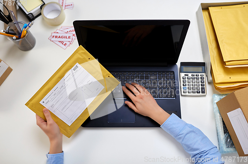 Image of hands with laptop and envelope at post office