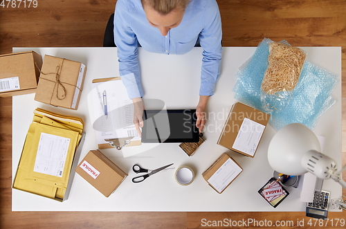 Image of woman with tablet pc and clipboard at post office