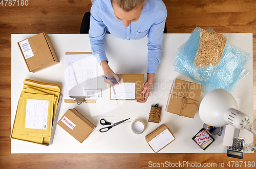 Image of close up of woman filling postal form at office