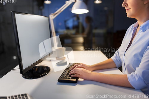 Image of businesswoman working on computer at night office