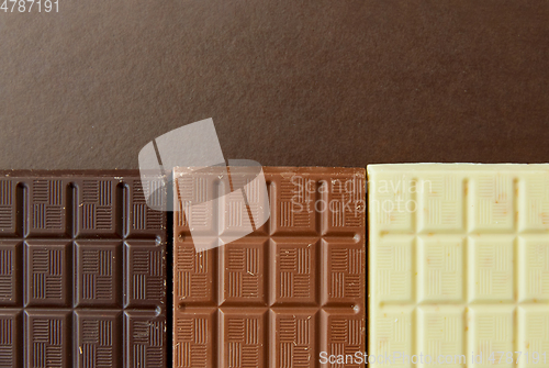 Image of different kinds of chocolate on brown background