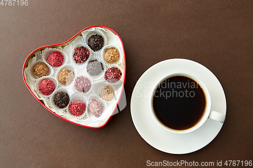 Image of candies in heart shaped chocolate box and coffee