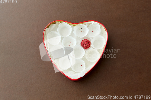 Image of one candy in red heart shaped chocolate box