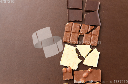 Image of different kinds of chocolate on brown background