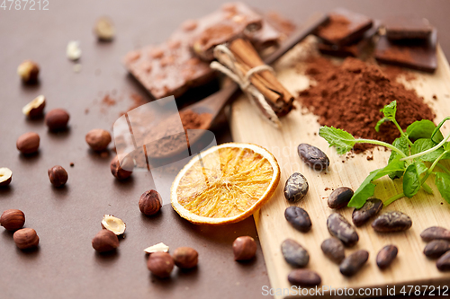 Image of chocolate with hazelnuts, cocoa beans and orange