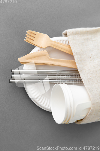 Image of wooden forks, knives and paper cups on plate